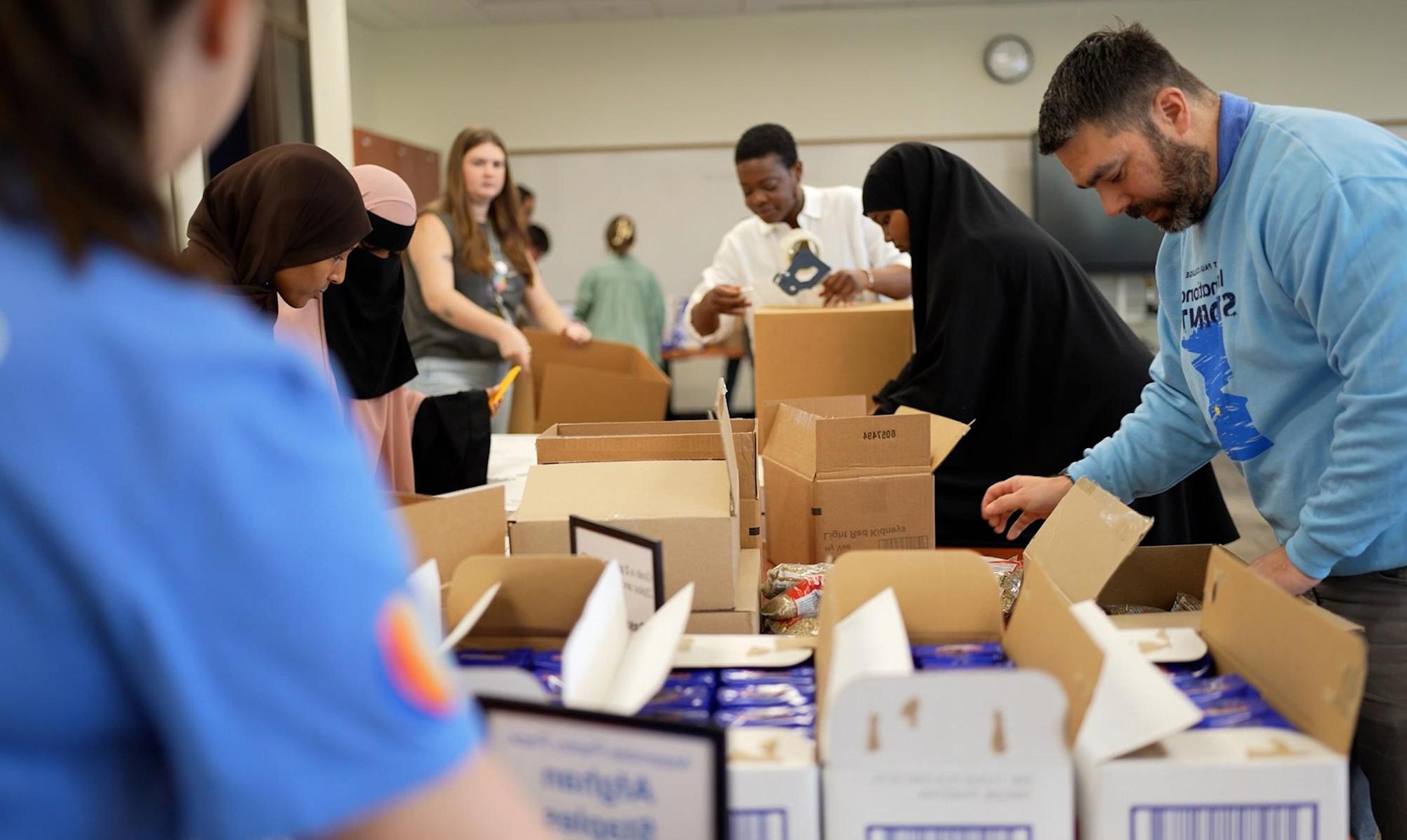 photo of VP Greg Rathert, staff, and students packing boxes